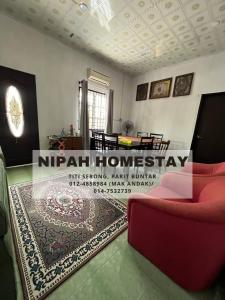 a living room with a red couch and a rug at Nipah Homestay Parit Buntar in Parit Buntar