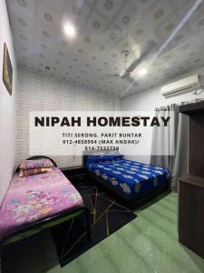 Zimmer mit 2 Betten und einem Schild, das die Privatunterkunft Nirwana liest in der Unterkunft Nipah Homestay Parit Buntar in Parit Buntar