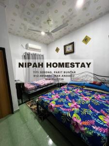 Nipah Homestay Parit Buntar في باريت بونتار: سرير في غرفة مع علامة على الحائط