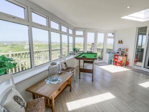 a living room with a pool table and windows at Minerva in Holyhead