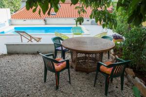 - une table et des chaises en face de la piscine dans l'établissement Apartment Kova - with pool, à Stari Grad