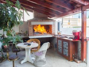 une cuisine extérieure avec une table et une cheminée dans l'établissement Apartment Kova - with pool, à Stari Grad