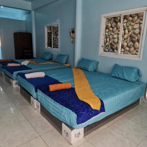 3 camas en una habitación con paredes azules en Haadrin village Fullmoon en Haad Rin
