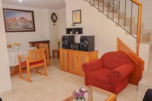 een woonkamer met een rode stoel en een tafel bij Apto duplex mandarina 2 niveles jardín y parqueo privado! in Sogamoso