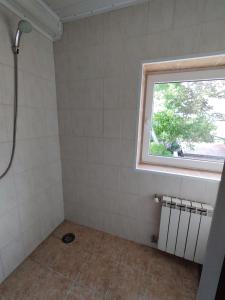 a bathroom with a shower and a window at ВИКЕНД in Karolino-Buhaz
