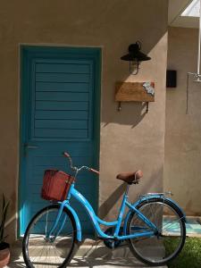 Una bicicleta azul estacionada frente a una puerta en Casa Tulup Sisal, en Sisal
