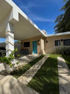 une maison avec une porte bleue et une cour dans l'établissement Casa Tulup Sisal, à Sisal