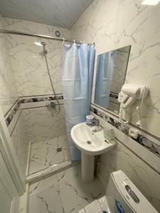 a white bathroom with a sink and a mirror at OLD STREET Guest House in Samarkand +40 photos