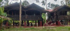 a house with a balcony in a forest at SRI MALAU 