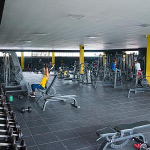 a woman is exercising in a gym with machines at Hotel Boutique San Juan in Neiva