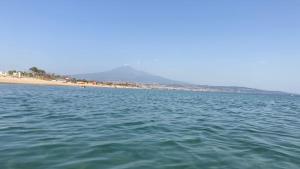 a large body of water with a beach in the background at Etna Spiaggia e Mare in Catania