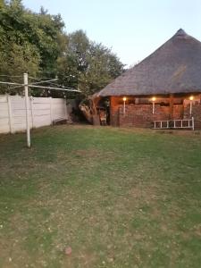 a brick building with a fence and a grass yard at Delightful Home in Pretoria