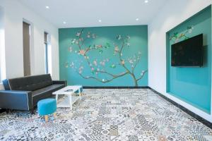 ein Wohnzimmer mit einer Couch und einem Baumwandbild in der Unterkunft Palm Villa 27 - 50M To The Sea in Vũng Tàu
