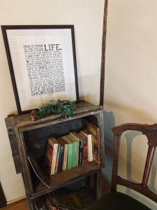 ein Bücherregal mit Büchern neben einem Stuhl in der Unterkunft 跳びしまBASE in Mitarai