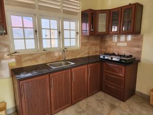 - une cuisine avec des placards en bois et un évier dans l'établissement Cross Ceylon, à Negombo
