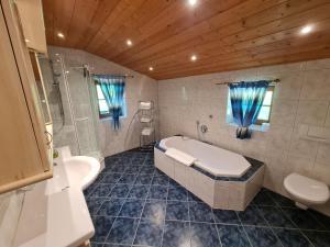 a bathroom with a tub and a toilet and a sink at Lauchlehen in Bischofswiesen +55 photos