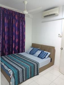 een bed in een kamer met paarse gordijnen bij 3rd floor apartment with 2 bedroom and no elevator in Kota Bharu