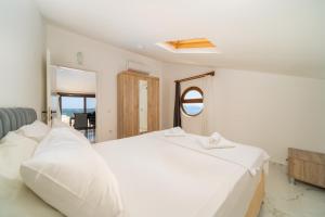 a bedroom with a large white bed and a window at Golden Rose Suit pension in Kaş