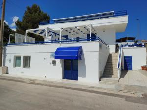 a white building with a blue awning on it at Bed and breakfast Delfino Blu in Torre Vado