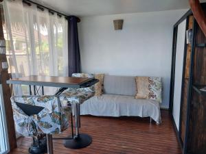 uma sala de estar com uma mesa e um sofá em Faré Mahi Mahi em Uturoa