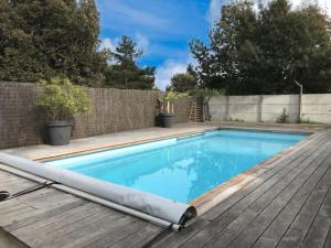 een zwembad met een houten terras en een hek bij Maison Saint-Vincent-sur-Jard, 5 pièces, 8 personnes - FR-1-336-139 in Saint-Vincent-sur-Jard