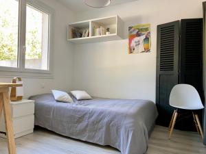 een slaapkamer met een bed, een stoel en een raam bij Maison Saint-Vincent-sur-Jard, 5 pièces, 8 personnes - FR-1-336-139 in Saint-Vincent-sur-Jard