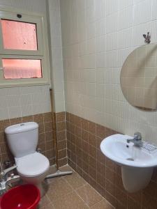 łazienka z toaletą i umywalką w obiekcie Villa Front Beach First row family only w mieście Ajn Suchna