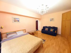 a bedroom with a bed and a chair in it at "Золотой Квадрат" Центр Квартира - "Golden Square" Apart in Almaty