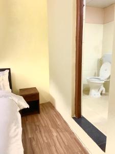 - une salle de bains avec toilettes et un lit dans une chambre dans l'établissement Ocean Inn, à Katmandou