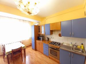 a kitchen with blue cabinets and a table and a sink at "Золотой Квадрат" Центр Квартира - "Golden Square" Apart in Almaty