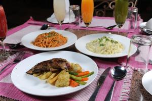 a table with plates of food on a pink table cloth at Apsara Boutique Hotel in Kathmandu