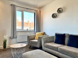 a living room with two chairs and a couch and a table at Lovely Serviced Apartment - Near Doncaster Hospital in Doncaster