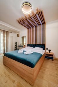 duża sypialnia z dużym łóżkiem z niebieską pościelą w obiekcie NorthBay Sunrise View - Infinity Pool & Spa Resort w mieście Năvodari