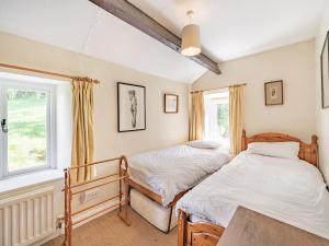 two beds in a room with two windows at Waingap in Crook