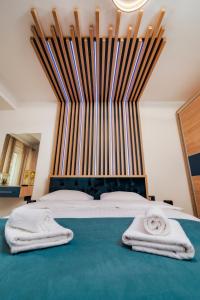 sypialnia z dużym łóżkiem z dwoma ręcznikami w obiekcie NorthBay Sunrise View - Infinity Pool & Spa Resort w mieście Năvodari