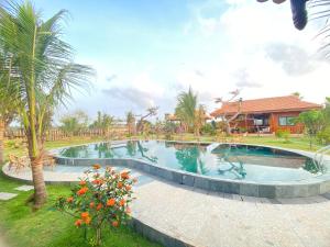a large swimming pool in a yard with a house at BlackPink Homestay Hồ Tràm in Xóm Trương Quít