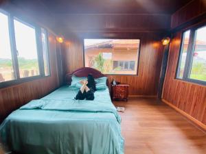 a woman laying on a bed in a room with windows at BlackPink Homestay Hồ Tràm in Xóm Trương Quít
