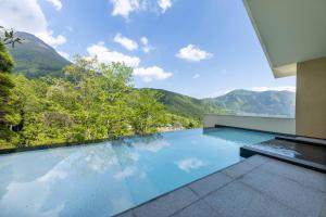 uma piscina com vista para as montanhas em ENOWA em Yufu