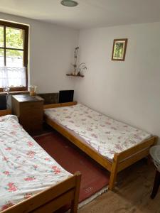 1 dormitorio con 2 camas y ventana en Dom nad rzeką, en Neple