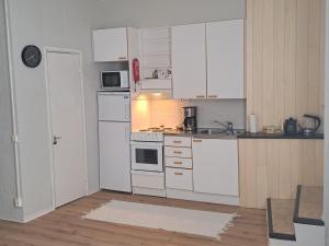 una cocina con armarios blancos y electrodomésticos blancos en Huoneisto Neristan Kokkola, en Kokkola