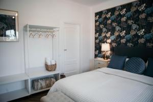 1 dormitorio con 1 cama y papel pintado con motivos florales en Flowers & Faces Guesthouse, en Ponte de Lima