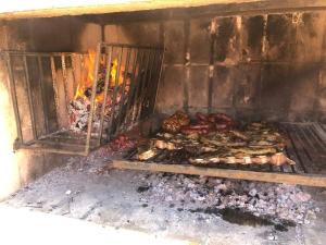 a grill with a bunch of food cooking in it at Casa Alquiler Cuchilla Alta 1 in Cuchilla Alta +17 photos
