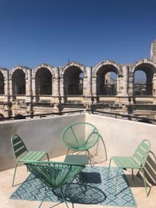 two chairs and a table in front of a building at Entre les Arènes et la Major in Arles