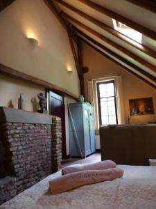 a living room with a brick fireplace and a stove at Landgoedhoeve Vosbergen in Heerde