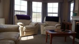 a living room with a couch and two chairs and a table at Bridge Farm Caravan in Buxton