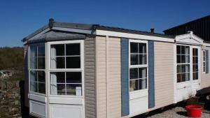 una casa pequeña con techo gris y ventanas en Bridge Farm Caravan, en Buxton