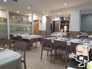 un restaurante con mesas y sillas blancas y un camarero de dibujos animados en Regina Bona Rooms en Modugno