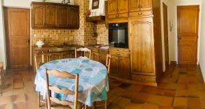 a kitchen with a table and a kitchen with wooden cabinets at Le refuge des canards in Saint-Aubin-le-Cloud