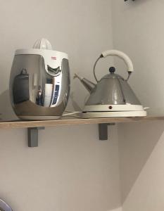 a toaster and a tea kettle on a shelf at Entre les Arènes et la Major in Arles