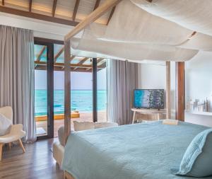 فوشيفارو المالديف في Fushifaru: غرفة نوم مع سرير وإطلالة على المحيط